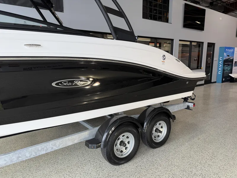 Slide: The Image of 2025 Sea Ray SPX230 boat on trailer in showroom, black and white design. - 3