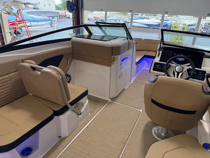 Slide: The Image of 2025 Sea Ray SPX230 boat interior with tan seating and modern dashboard. - 34