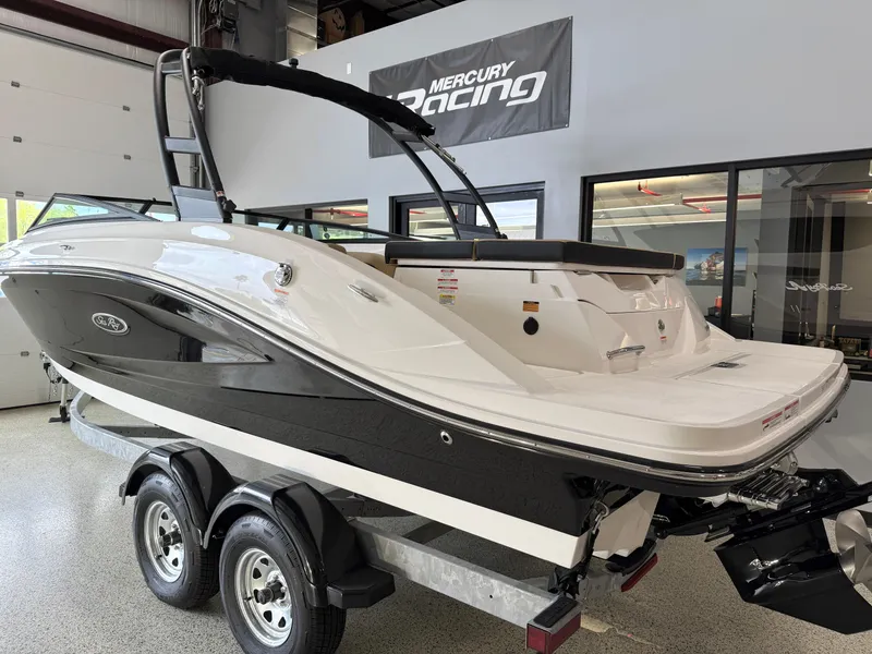 Slide: The Image of 2025 Sea Ray SPX230 boat on trailer in showroom, Mercury Racing sign above. - 4