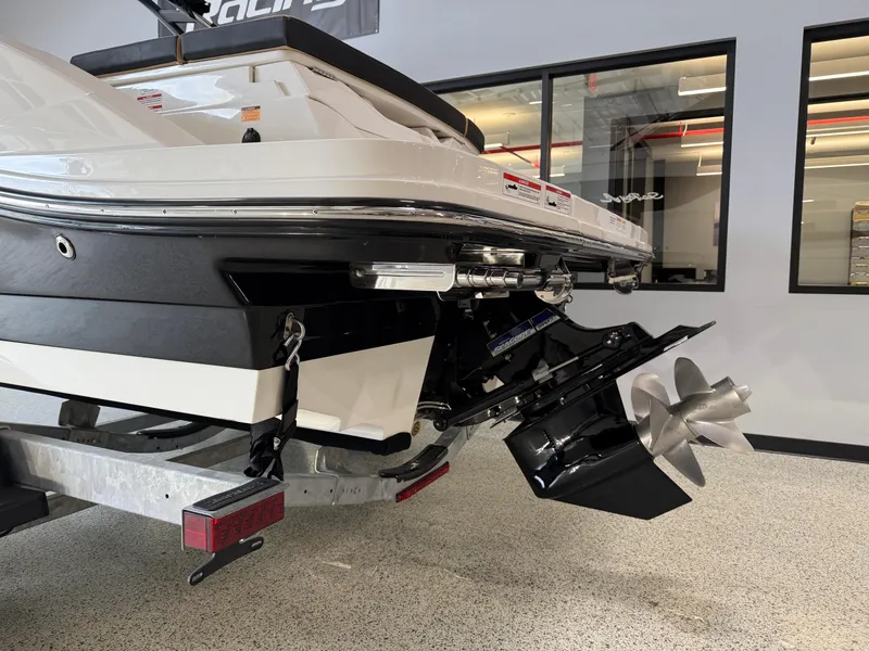 Slide: The Image of 2025 Sea Ray SPX230 boat stern with propeller, displayed indoors on a trailer. - 5