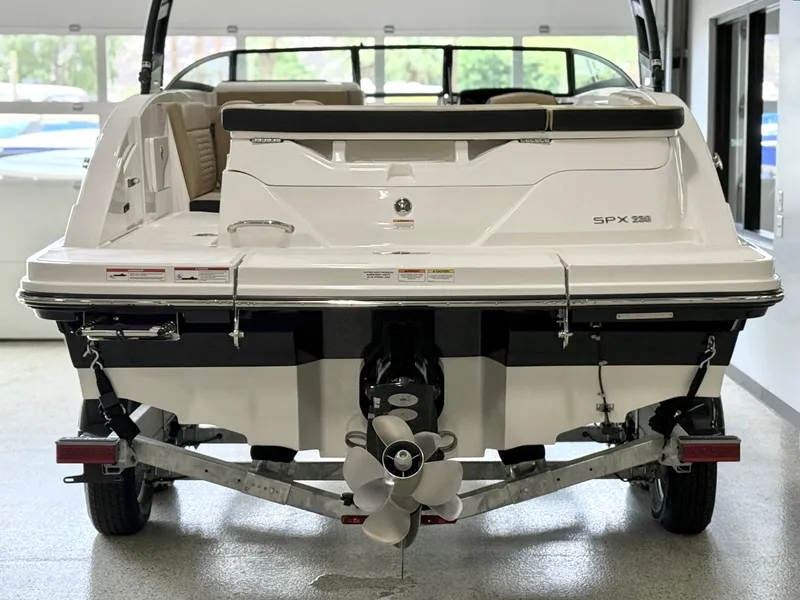 Slide: The Image of 2025 Sea Ray SPX230 boat rear view in showroom, showcasing sleek design and powerful engine. - 6