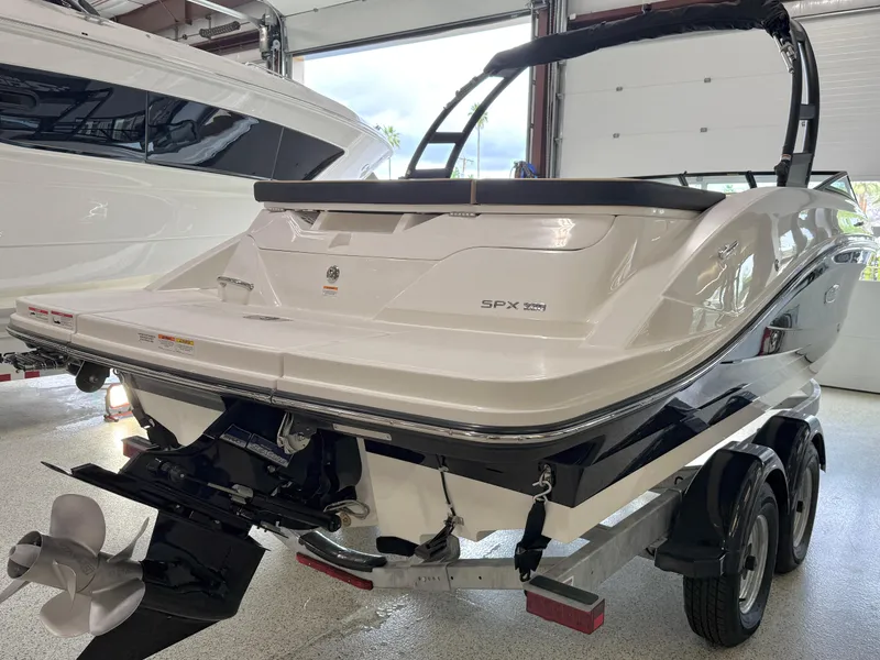 Slide: The Image of 2025 Sea Ray SPX230 boat on trailer in showroom, rear view. - 7