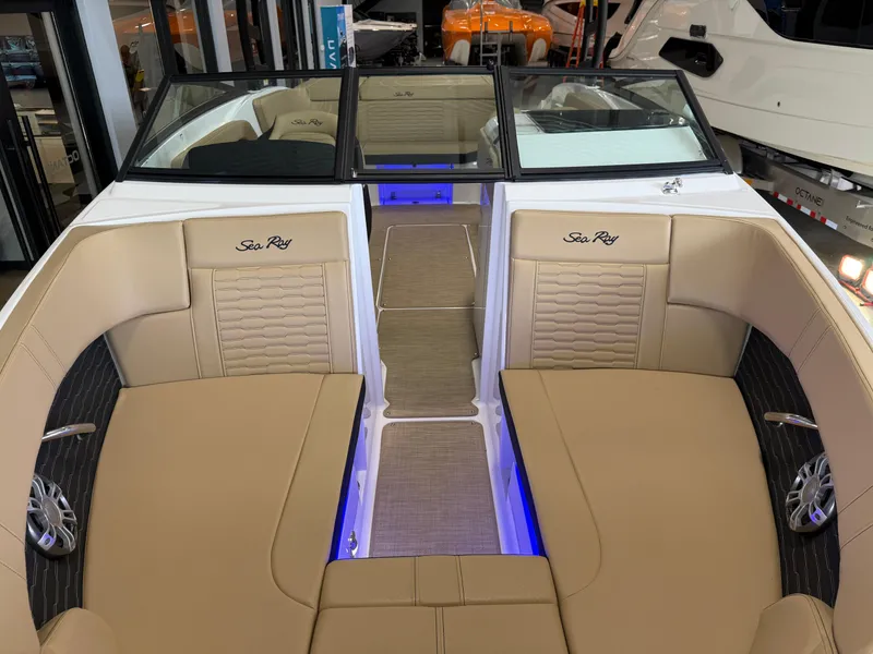 Slide: The Image of 2025 Sea Ray SPX230 boat interior with beige seating and blue accent lighting. - 9