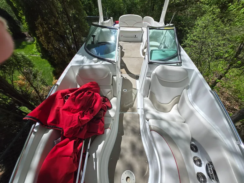 Slide: The Image of 2009 Azure AZ298 boat interior with white seating and red fabric, surrounded by greenery. - 8