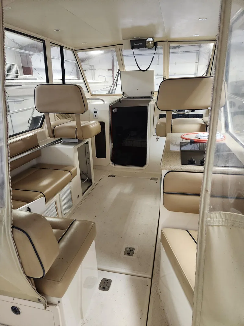 Slide: The Image of 2010 Mainship Pilot 31 interior with beige seating and spacious cabin layout. - 13