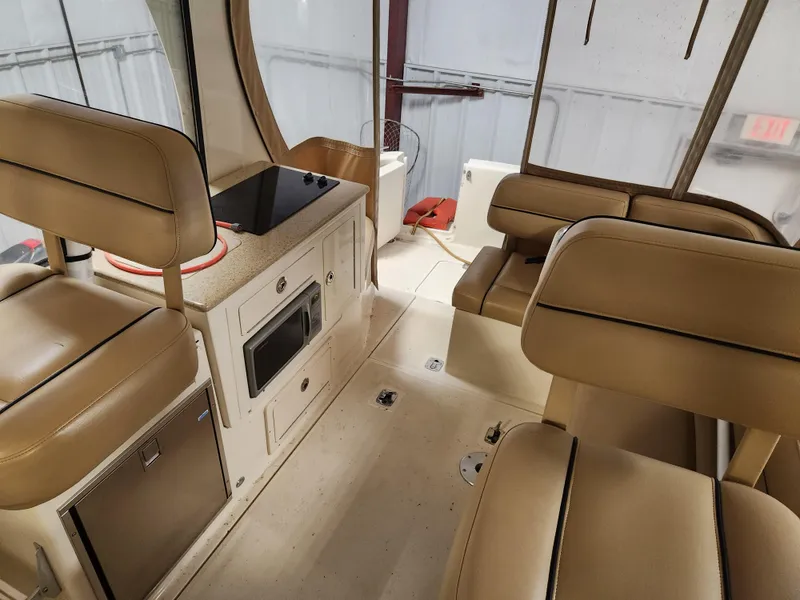 Slide: The Image of Interior of 2010 Mainship Pilot 31 boat with beige seating and compact kitchen area. - 14