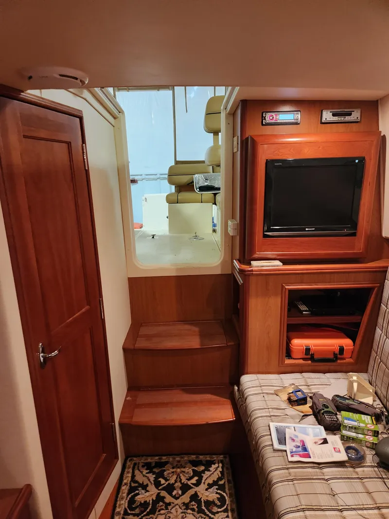 Slide: The Image of Interior of 2010 Mainship Pilot 31 boat with wood finish, TV, and seating area. - 16