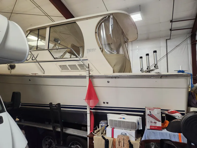 Slide: The Image of 2010 Mainship Pilot 31 boat stored indoors with various items nearby. - 18