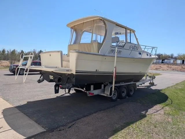 Slide: The Image of 2010 Mainship Pilot 31 boat on a trailer, parked outdoors on a sunny day. - 21