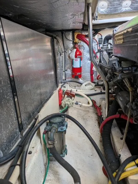 Slide: The Image of Engine room of a 2010 Mainship Pilot 31 boat, featuring mechanical components and fire extinguisher. - 25