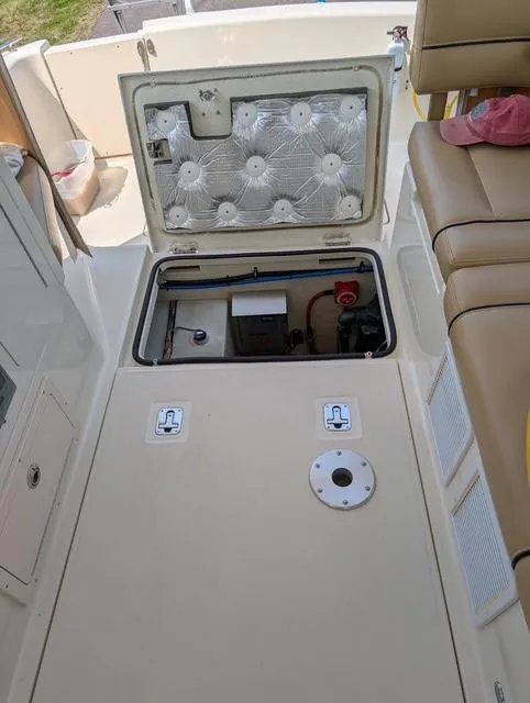 Slide: The Image of 2010 Mainship Pilot 31 engine compartment with open hatch, showcasing interior components and seating area. - 26