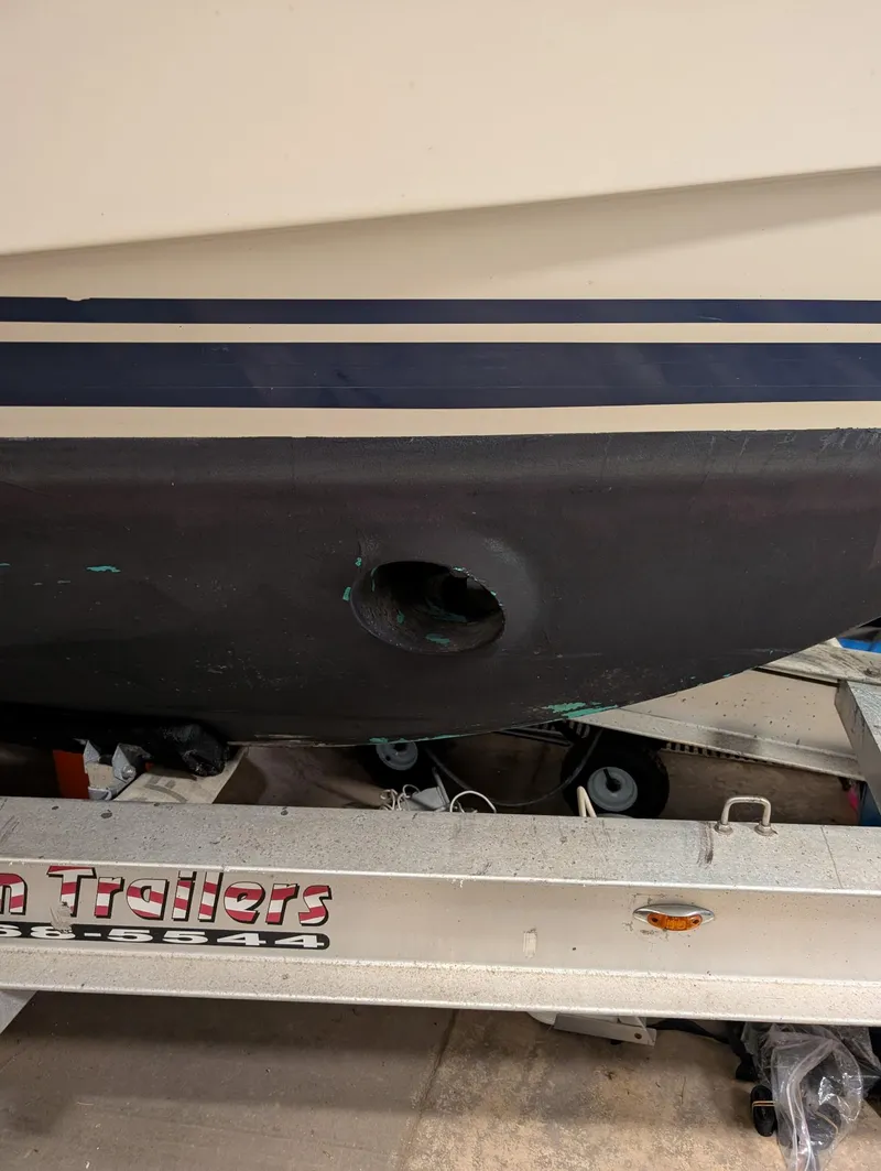 Slide: The Image of 2010 Mainship Pilot 31 boat hull on trailer, featuring a visible hole. - 7