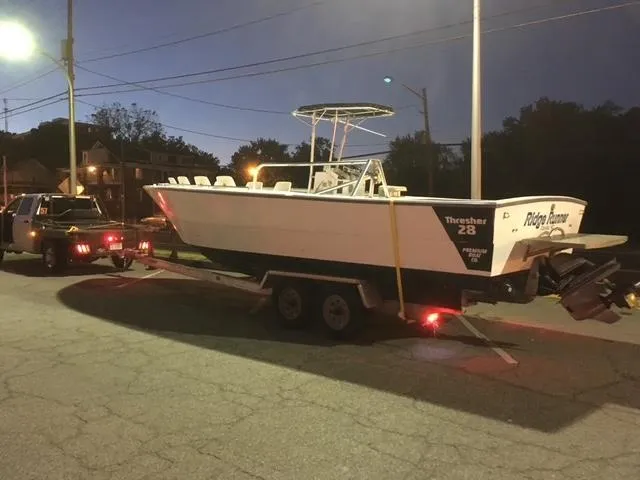 Slide: The Image of 1999 Sea Ray Thresher boat on trailer at dusk, parked on street. - 0