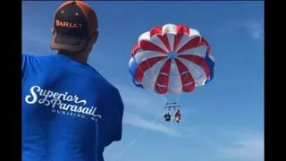 Slide: The Image of Man observing parasailing under clear blue sky, wearing "Superior Parasail" shirt. - 2