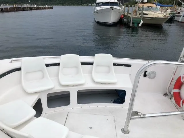 Slide: The Image of 1999 Sea Ray Thresher boat with white seating, docked at a marina. - 7