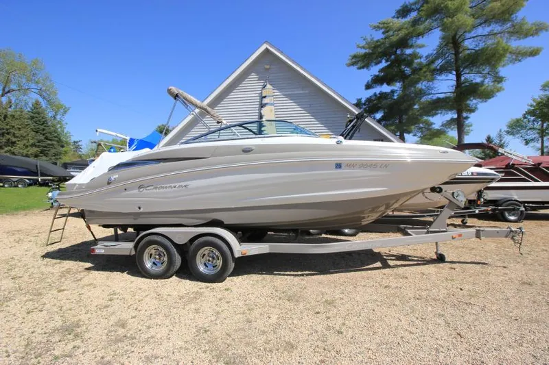 Slide: The Image of 2016 Crownline Eclipse E2 boat on trailer, parked outdoors near a house. - 0