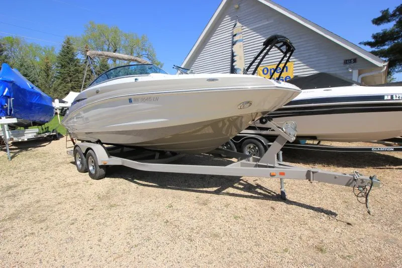 Slide: The Image of 2016 Crownline Eclipse E2 boat on trailer, parked outdoors near a building. - 1