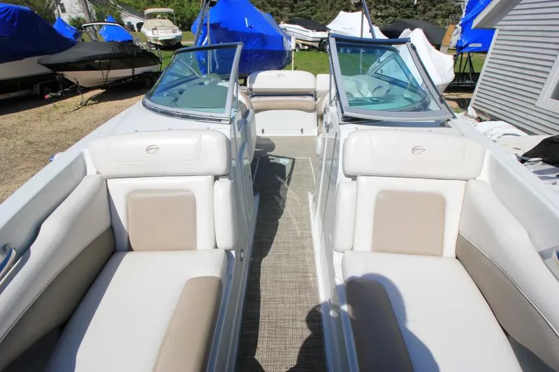 Slide: The Image of 2016 Crownline Eclipse E2 boat interior with beige and white seating, docked outdoors. - 23