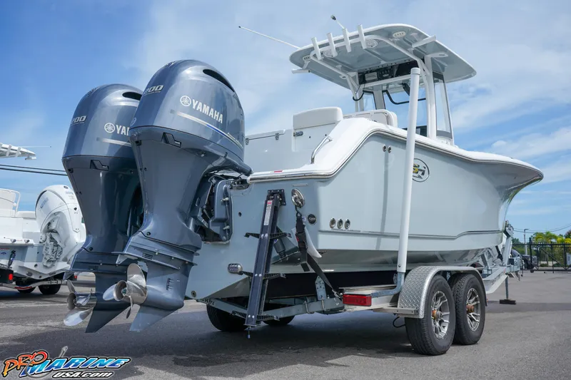 Slide: The Image of 2022 Sea Hunt GAMEFISH 27 CB boat with dual Yamaha engines on a trailer. - 15