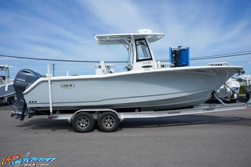 Slide: The Image of 2022 Sea Hunt GAMEFISH 27 CB boat on trailer, side view, clear sky background. - 17