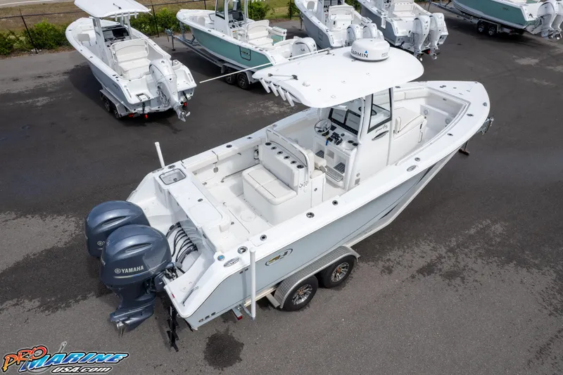 Slide: The Image of 2022 Sea Hunt GAMEFISH 27 CB boat with dual Yamaha engines on a trailer. - 24
