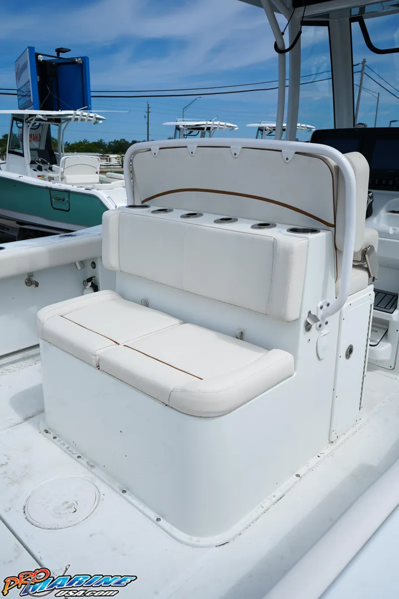 Slide: The Image of 2022 Sea Hunt GAMEFISH 27 CB boat seating with white cushioned bench and rod holders. - 33