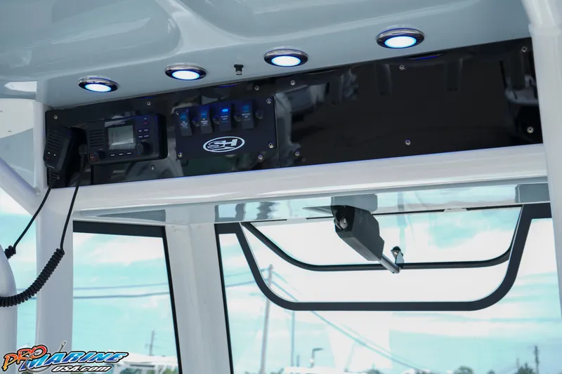 Slide: The Image of 2022 Sea Hunt GAMEFISH 27 CB boat console with electronic controls and overhead lighting. - 35