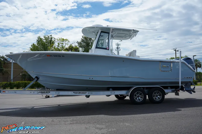 Slide: The Image of 2022 Sea Hunt GAMEFISH 27 CB boat on trailer, parked outdoors under cloudy sky. - 5