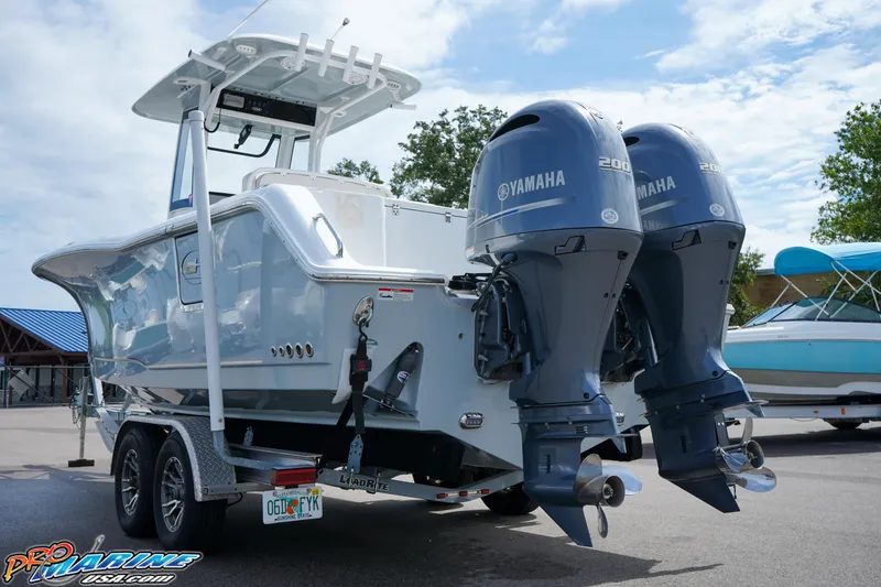 Slide: The Image of 2022 Sea Hunt GAMEFISH 27 CB boat with dual Yamaha engines on a trailer. - 9