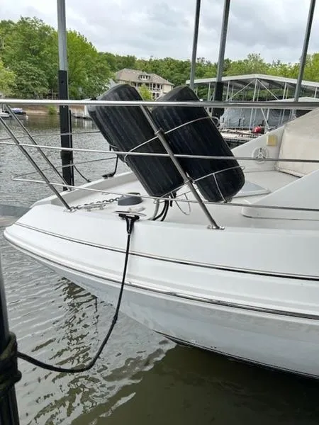 Slide: The Image of 2005 Carver Mariner 360 docked, featuring bow rail and fenders on a calm lake. - 17