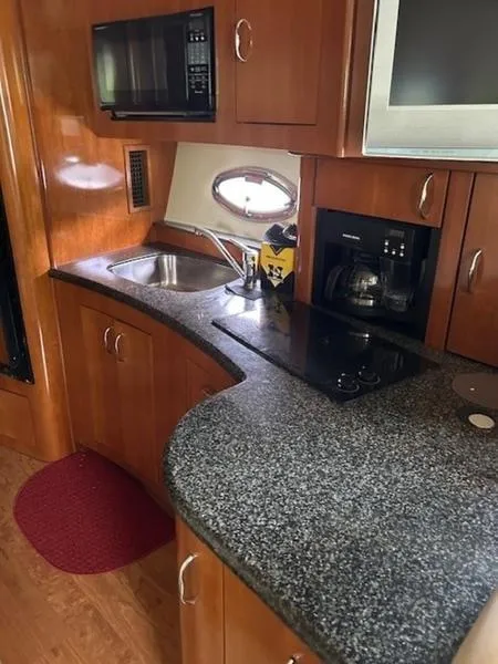 Slide: The Image of 2005 Carver Mariner 360 yacht kitchen with granite countertop, sink, stove, and microwave. - 19