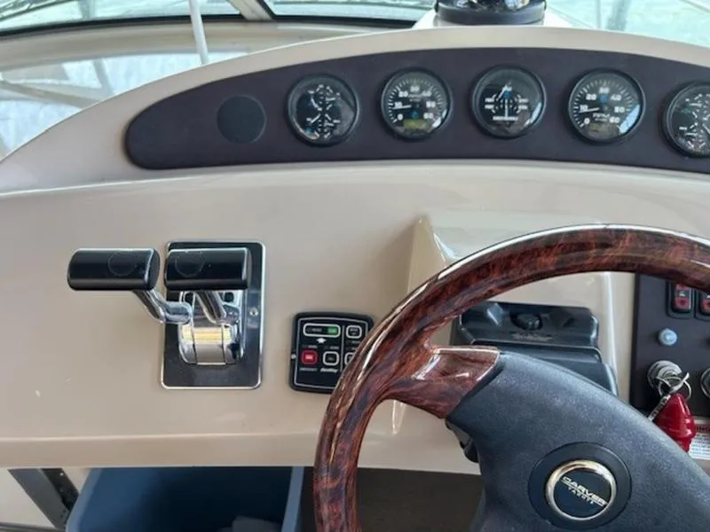 Slide: The Image of 2005 Carver Mariner 360 helm with gauges, controls, and wood-accented steering wheel. - 12
