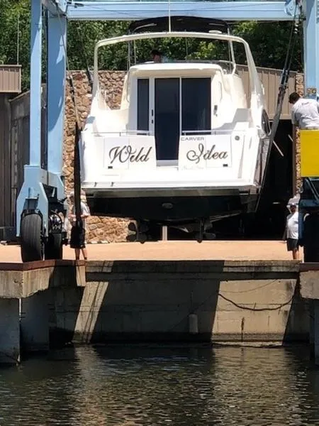 Slide: The Image of 2005 Carver Mariner 360 yacht named "Wild Idea" being lifted at a dock. - 13