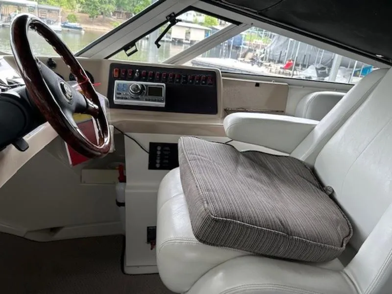 Slide: The Image of 2005 Carver Mariner 360 helm with steering wheel, control panel, and cushioned captain's seat. - 3