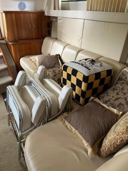 Slide: The Image of Interior of 2005 Carver Mariner 360 with beige sofa, cushions, and foldable chairs. - 7