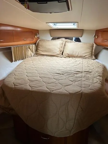 Slide: The Image of 2005 Carver Mariner 360 cabin with cozy bed and wooden storage cabinets. - 8