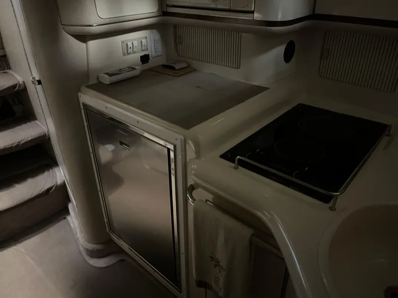 Slide: The Image of 1996 Sea Ray 330 Sundancer interior kitchen with stove, fridge, and counter space. - 23