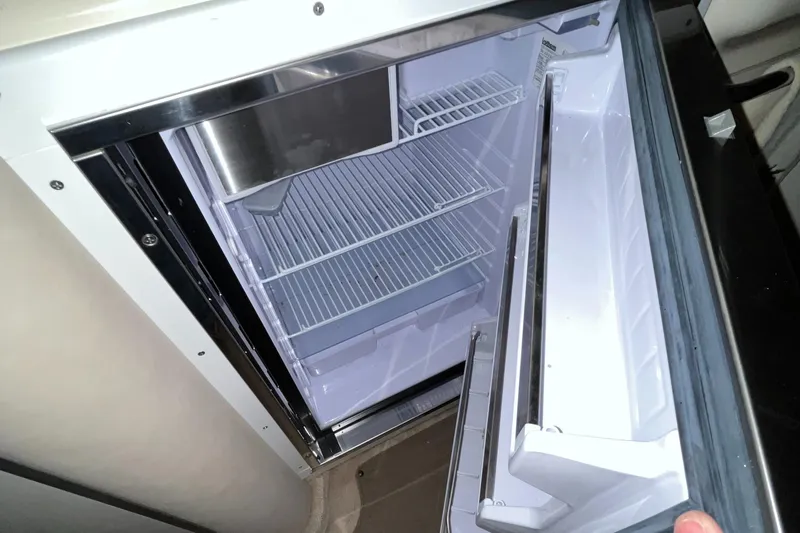 Slide: The Image of Open refrigerator inside 1996 Sea Ray 330 Sundancer boat, showing empty shelves. - 29