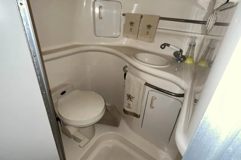 Slide: The Image of Compact bathroom in 1996 Sea Ray 330 Sundancer yacht with toilet, sink, and storage. - 31