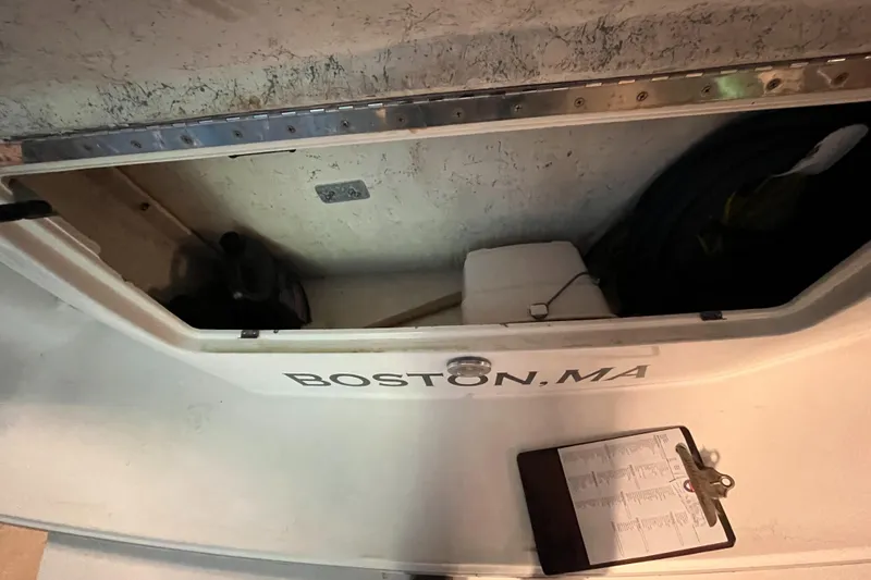 Slide: The Image of 1996 Sea Ray 330 Sundancer storage compartment with Boston, MA label and clipboard. - 35