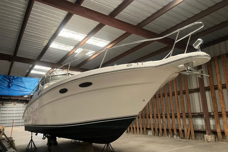 Slide: The Image of 1996 Sea Ray 330 Sundancer yacht in storage, showcasing sleek design and sturdy build. - 4