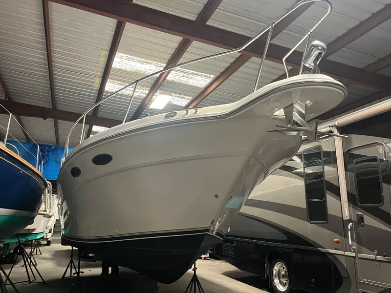 Slide: The Image of 1996 Sea Ray 330 Sundancer boat stored indoors, showcasing sleek design and sturdy build. - 6