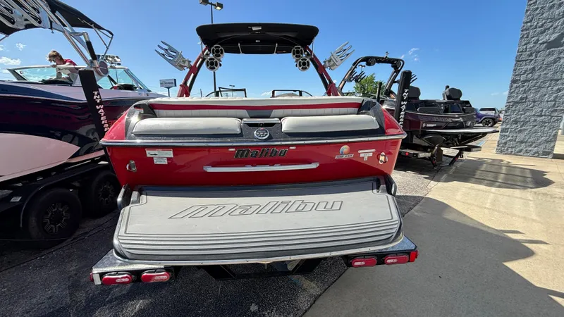 Slide: The Image of 2015 Malibu Wakesetter 22 MXZ boat, rear view, red color, parked outdoors. - 2