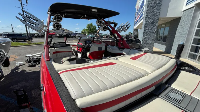 Slide: The Image of 2015 Malibu Wakesetter 22 MXZ boat with red and white interior, parked outdoors. - 3