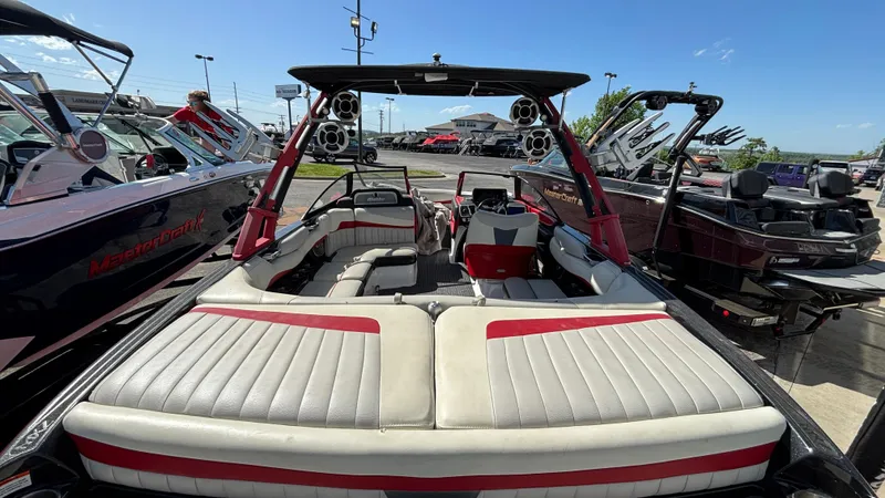 Slide: The Image of 2015 Malibu Wakesetter 22 MXZ boat with red and white interior, parked outdoors. - 4