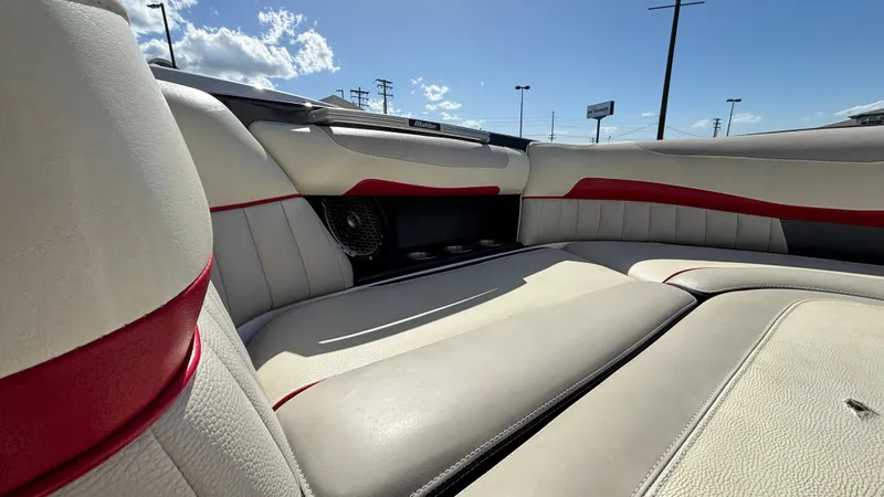 Slide: The Image of 2015 Malibu Wakesetter 22 MXZ interior with white and red upholstery under a sunny sky. - 7