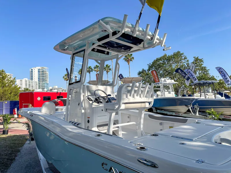 Slide: The Image of 2025 Caymas 24 HB boat displayed outdoors with cityscape and palm trees in background. - 10