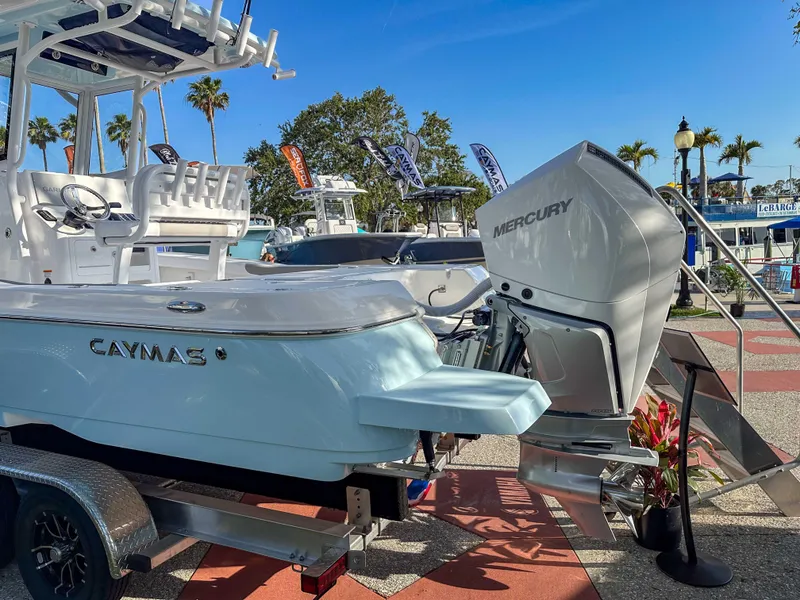 Slide: The Image of 2025 Caymas 24 HB boat with Mercury engine on display outdoors. - 11