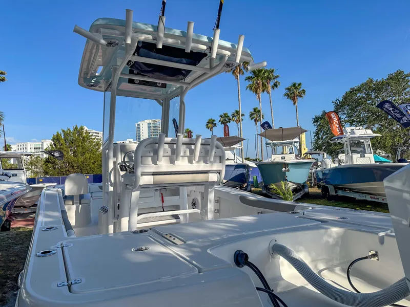Slide: The Image of 2025 Caymas 24 HB boat with T-top, displayed outdoors under clear blue sky. - 13