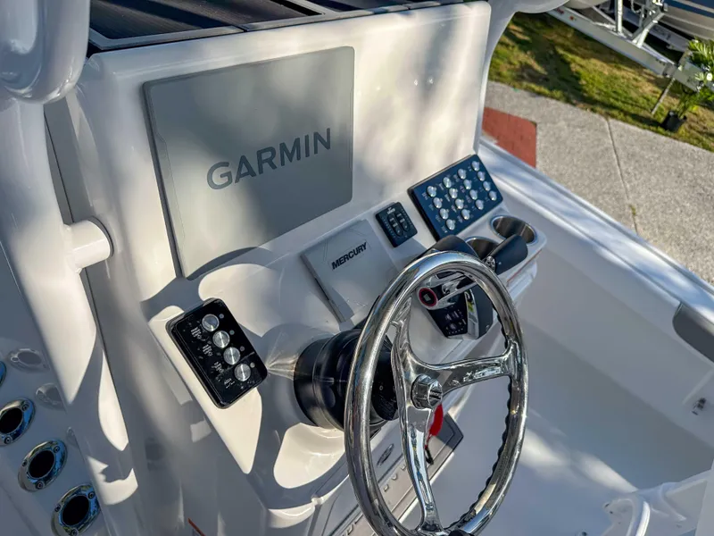 Slide: The Image of 2025 Caymas 24 HB boat dashboard with Garmin navigation system and steering wheel. - 18